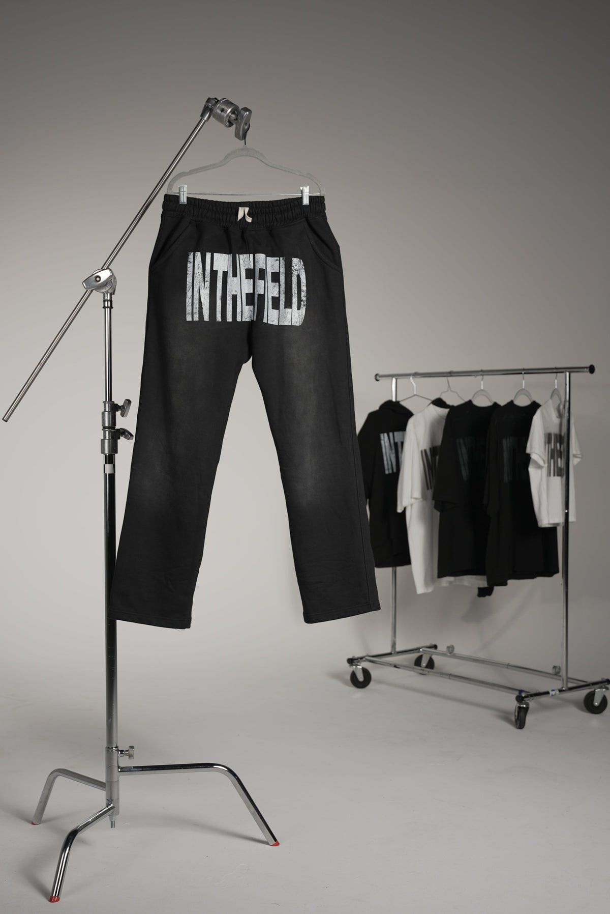 Black sweatpants with 'In The Field' branding on a white background. Industrial set. Set photoshoot